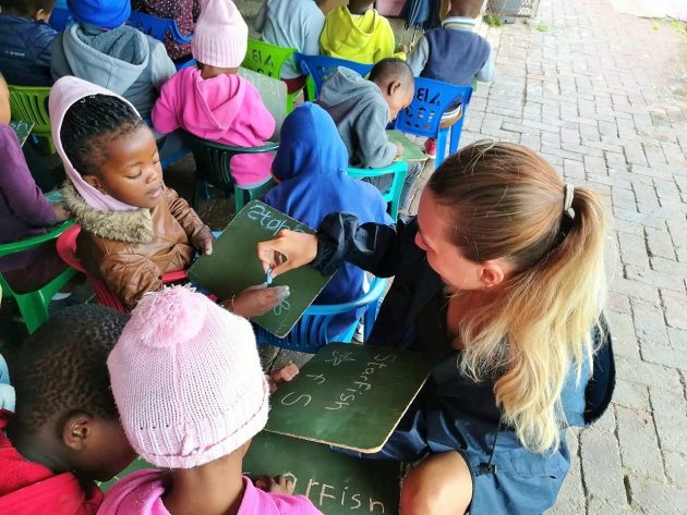 Volunteer teaching young children at a local pre school